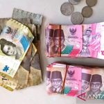 Petugas Dinas Satpol PP WH Kabupaten Aceh Barat memperlihatkan uang tunai sebesar Rp20.019.000,- yang diperoleh dari Khairul Mursalin. Foto: Antara