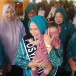 Pj Ketua TP PKK Aceh Utara Ny Awirdalina Mahyuzar menggendong bayi. Foto: Humas Aceh Utara