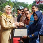 Penjabat Bupati Nagan Raya Fitriany Farhas menyerahkan penghargaan lingkungan kepada kepada sejumlah stakeholder. Foto: Humas Nagan Raya