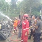 Petugas menyemprotkan air untuk memadamkan api yang membakar tiga rumah di Padang Sakti, Minggu, 14 Juli 2024.