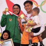 Ikbal Candra Pratama (Kaltim) dan Sarah Tria Monita (Jawa Timur) bersama anak-anak mereka usai meraih emas pencak silat PON XXI Aceh-Sumut di GOR Veteran, Medan, Sumatera Utara, Jumat (13/9/2024). Keduanya berhasil mengawinkan emas pencak silat sebanyak 5 kali. Foto: Tribunnews.com