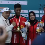 Ketua Umum Koni Aceh Kamaruddin Abu Bakar usai mengalungkan medali kepada pasangan ganda campuran soft tenis Aceh, Maulidan Laksana dan Ella Faradilla, Minggu, 15 September 2024. Foto: Istimewa
