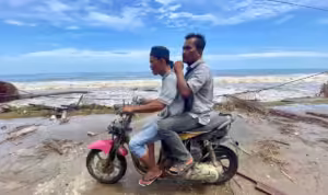 Pengendara sepeda motor melintas di jalan Gampong Lhok Pu'uk, Seunuddon, Aceh Utara, yang dhantam pasang purnama, Kamis, 19 September 2024. Foto: Line1.News/Fajar