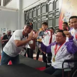 Pelatih Sepak Takrawa Gorontalo Herson Taha duduk di kursi roda setelah pengalungan medali emas di Gedung Idi Sport Center, Idi, Aceh Timur, Kamis (12/9/2024). Foto: Istimewa