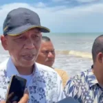 Plt Kepala Dinas PUPR Aceh Utara, Jaffar, saat mengecek kerusakan akibat banjir rob di Desa Lhok Pu'uk. Jafar mengatakan perlu dibangun pengaman pantai di desa tersebut. Foto: Line1.News/Fajar