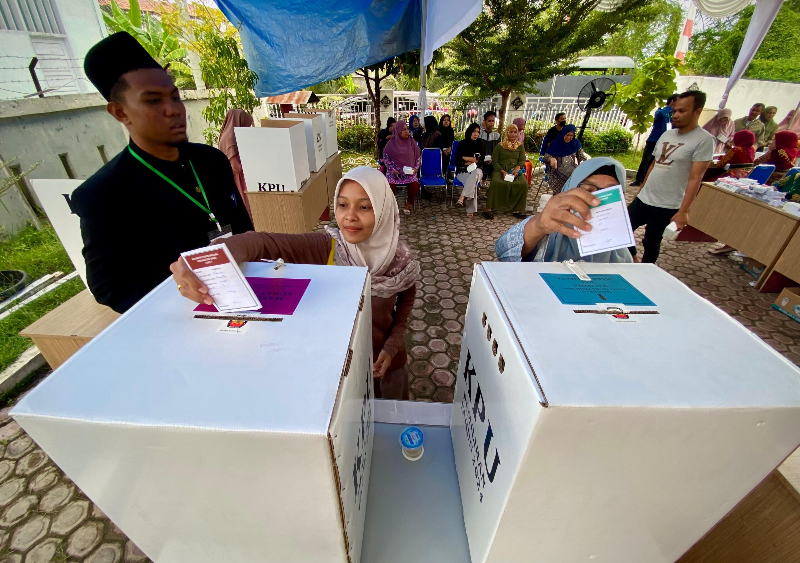 Warga Desa Uteunkot, Kecamatan Muara Dua, mengikuti simulasi pemungutan suara Pilkada 2024 di halaman kantor KIP Lhokseumawe, Minggu, 17 November. Foto: Line1.News/Fajar