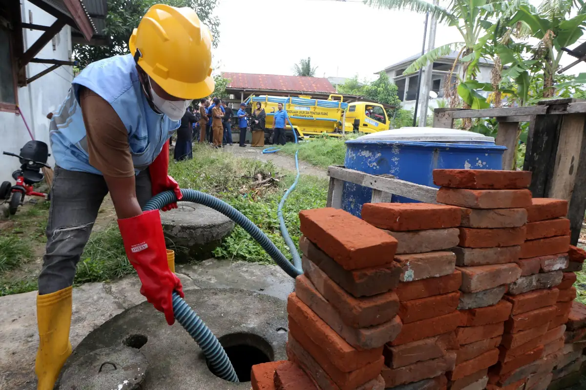 Petugas menyedot tinja dari sebuah septi tank di rumah warga