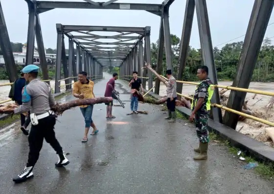 Bersihkan kayu terseret banjir di jembatan