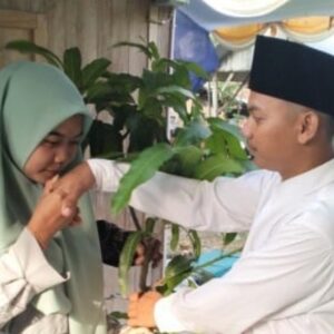 Mempelai wanita Aprilia mencium tangan Abi Yahya saat menerima mahar bibit pohon mangga di Rembang