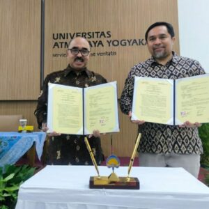 Ketua Umum AMSI dan Rektor UAJY menunjukkan naskah MoU